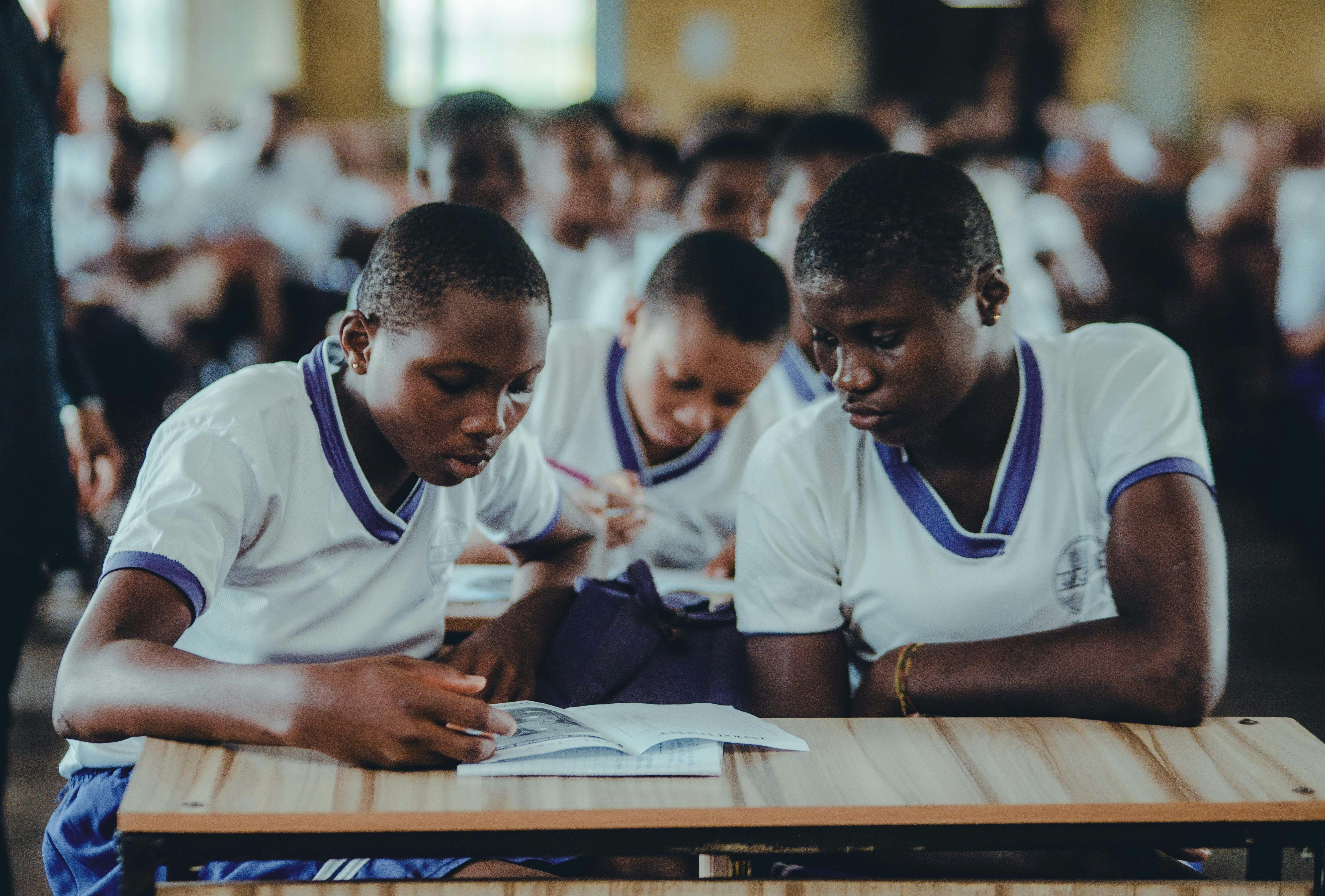 Matric learners studying from a textbook together